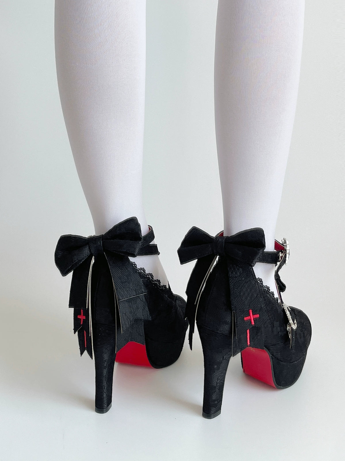 Rear view of Holy Relic Cross black heels with bows and red cross decoration