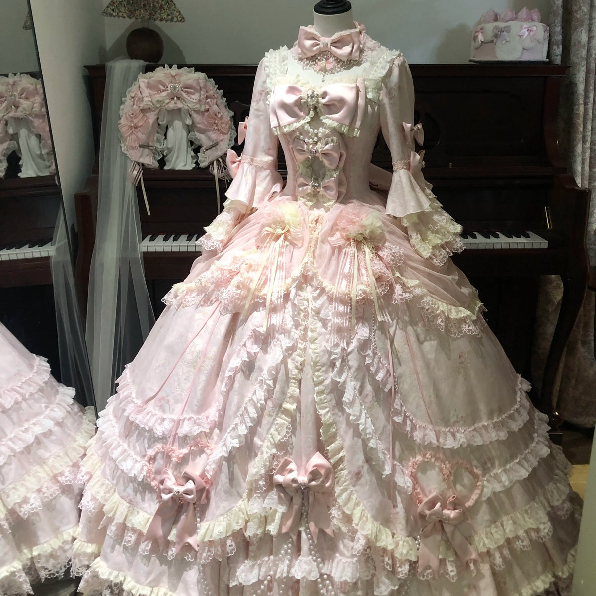 Full front view of pink Rococo Lolita gown with layered skirt and bows