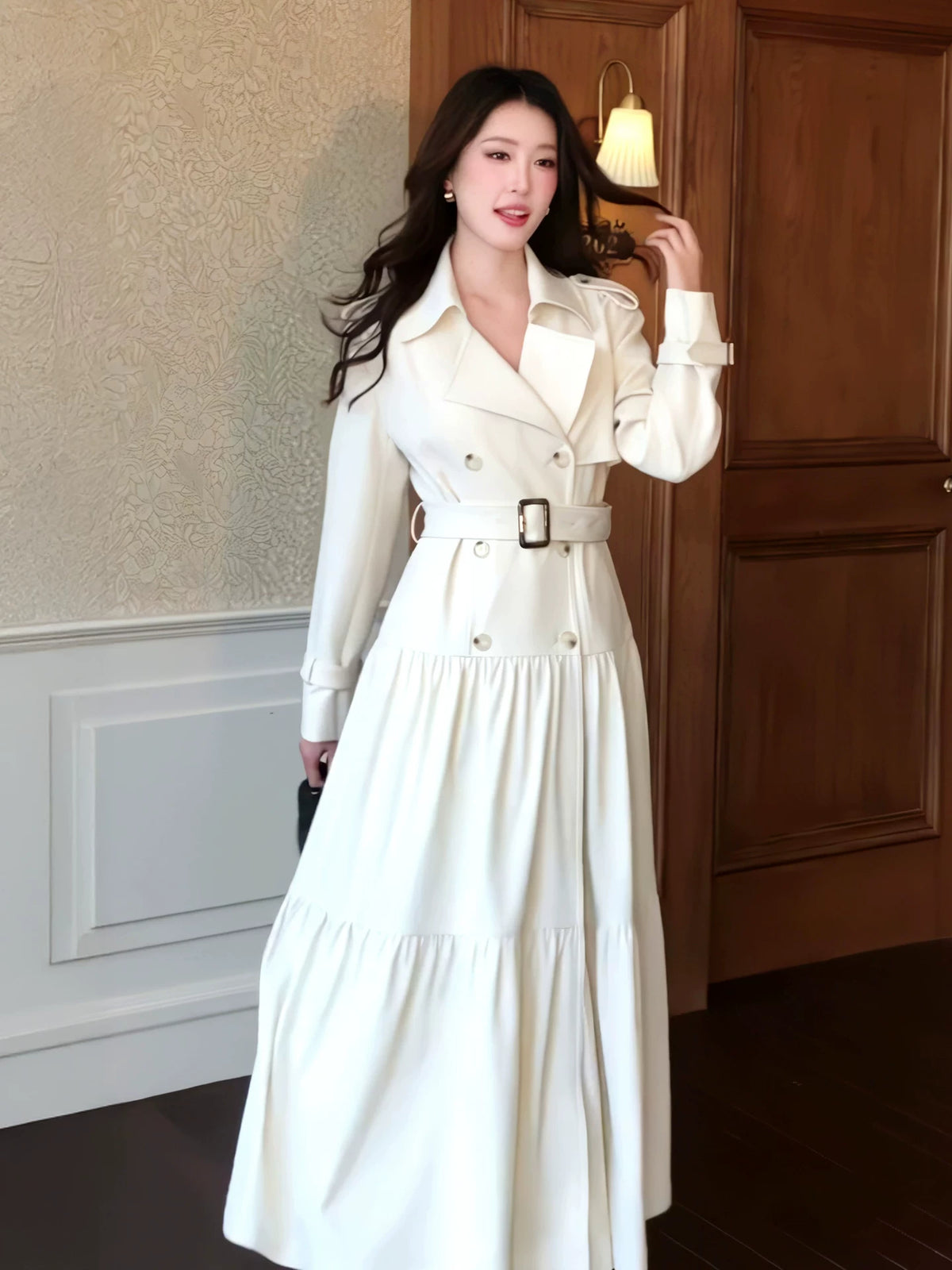 White wide-lapel trench coat belted to show flared hem