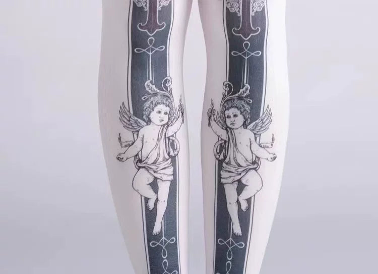 Close-up of black angel motifs on light-colored tights