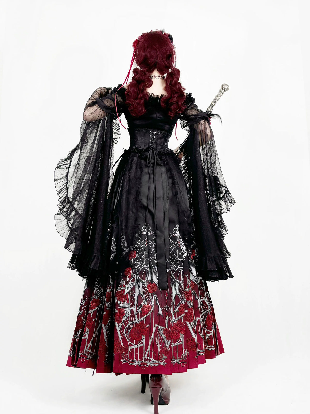 Rear view of black princess-sleeve blouse and red mamian skirt
