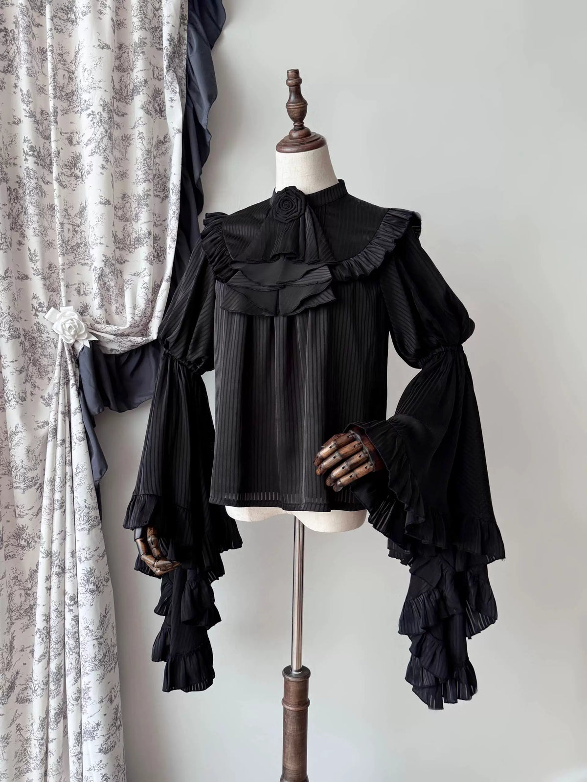 Black hime-sleeve blouse with lace bib on mannequin