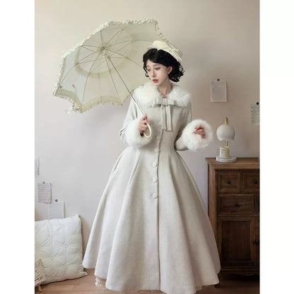 Ivory long coat styled with parasol showing full flared silhouette