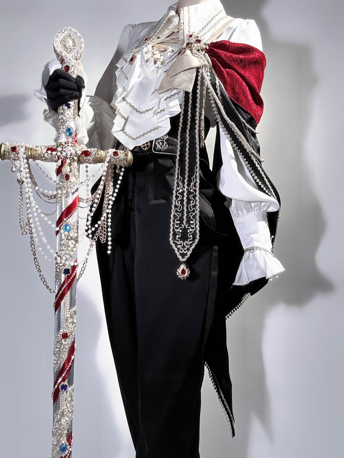 Knight’s Ceremony outfit detail showing decorated cape and high-waisted trousers