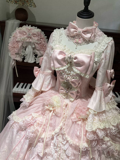 Pink Rococo Lolita gown close-up showing long sleeves, lace bodice and satin bows