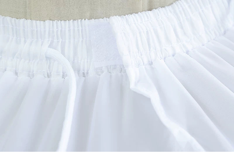 Close-up of a white skirt with beige lining and text overlay on a light background