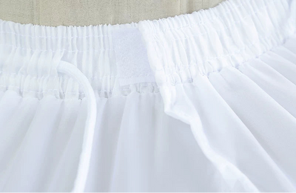 Close-up of a white skirt with beige lining and text overlay on a light background