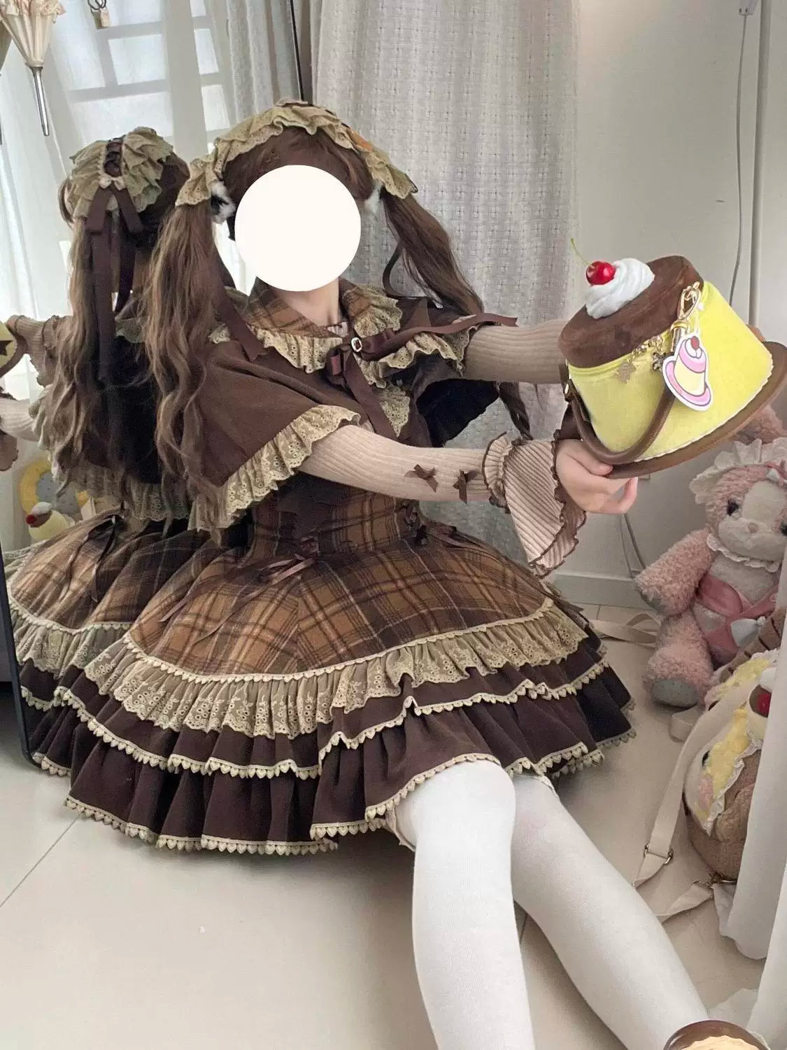 Seated view of brown plaid Lolita dress and matching cape