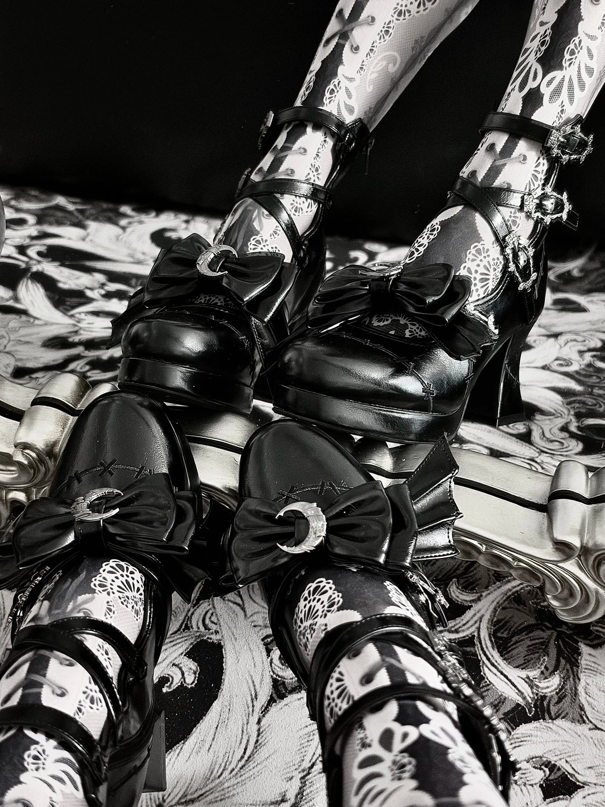 Glossy Black Gothic platform heels showing ribbon bow and silver-tone hardware by Sphenoid