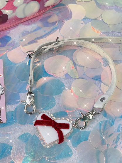 Halsband mit weißem herzförmigem Anhänger und roter Schleife