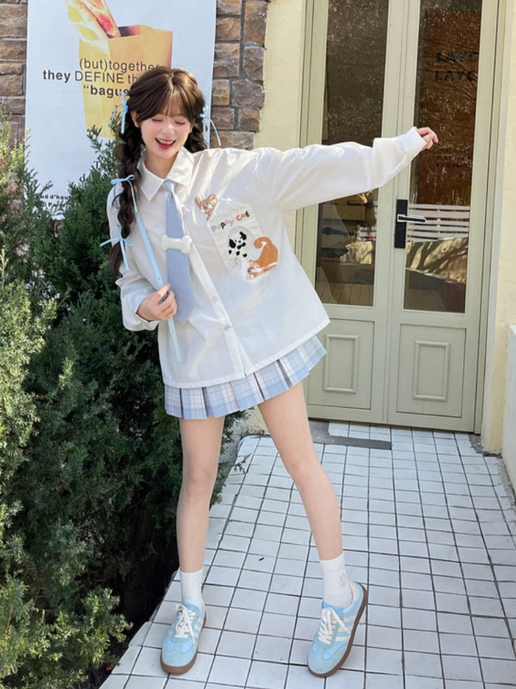 キティの青いネクタイとボーンパピーのアップリケがあしらわれた白いゆったりシャツ