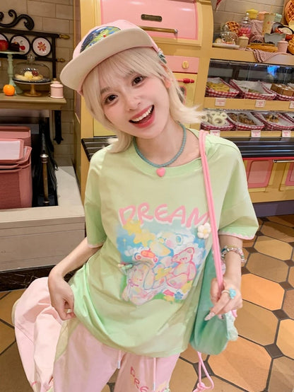 Grünes, lockeres Strick-T-Shirt mit Rundhalsausschnitt und Blumenakzenten und Teddybär-Print