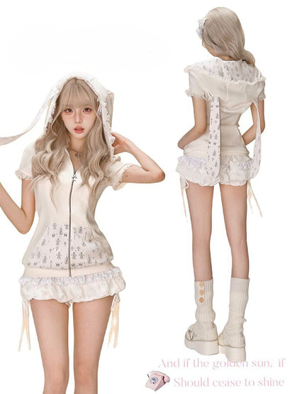 Jupe-short argentée ornée de dentelle blanche en forme de rose et de boutons étagés.