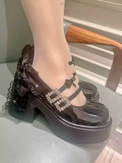 光沢のあるブラックのラインストーンバックルボウとフローラルブロックヒールのメリージェーン