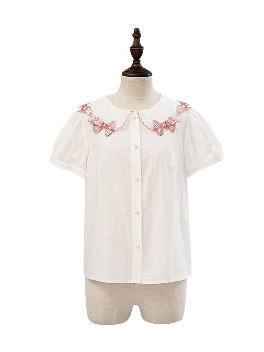 ピンクの蝶結びトリムカラーの白い半袖ブラウス