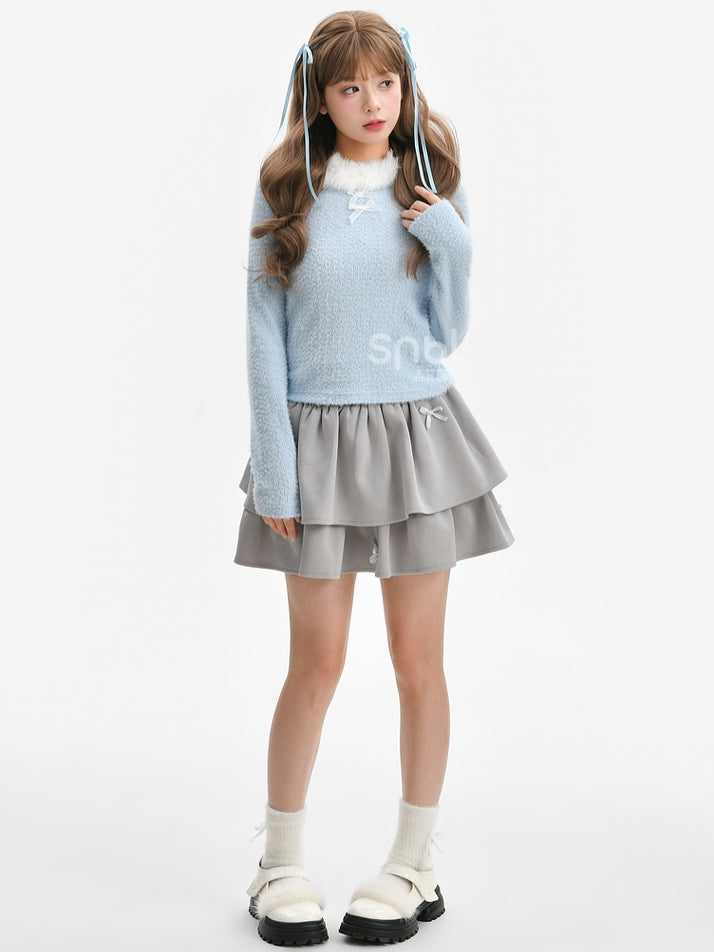 Blaues, langärmliges Oberteil mit Plüschbesatz am Ausschnitt und Schleifendetails