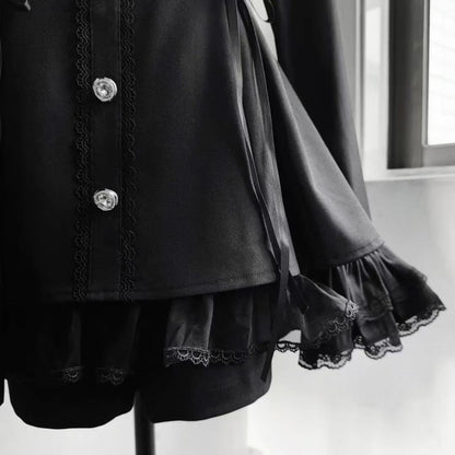 Close-up of black gothic Lolita dress buttons and flared lace-trimmed sleeve