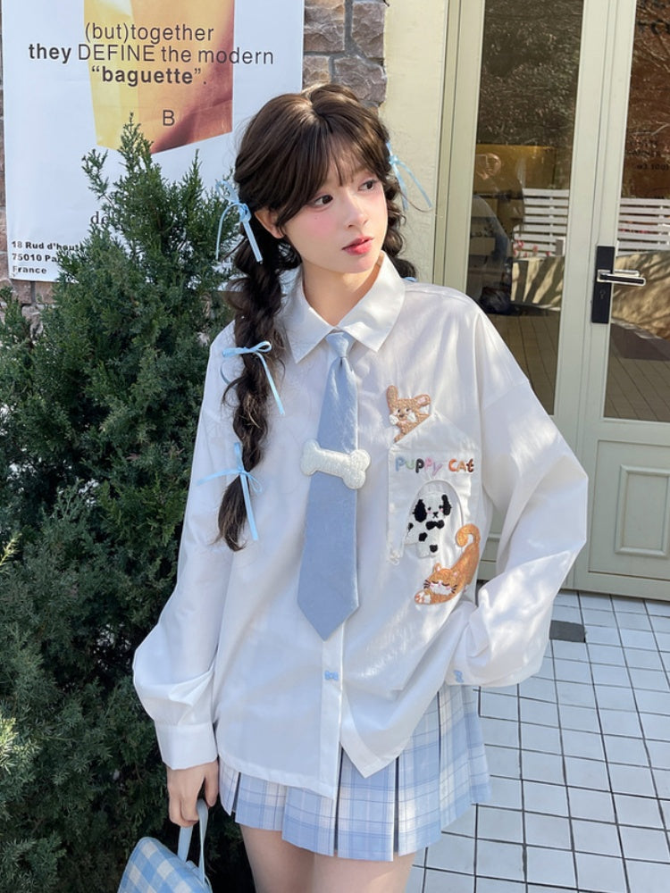 キティの青いネクタイとボーンパピーのアップリケがあしらわれた白いゆったりシャツ