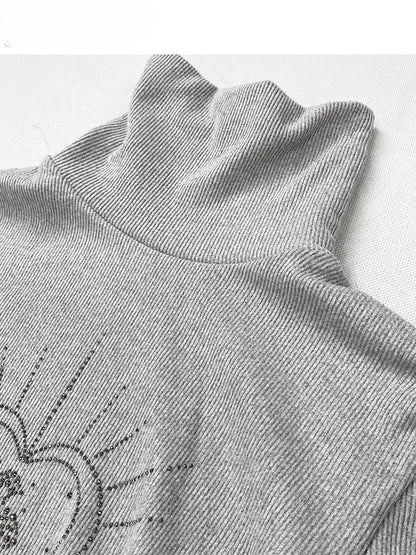 Hellgraues Stricktop mit hohem Halsausschnitt und herzförmigen Strasssteinen