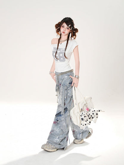 控えめなディテールのダメージ加工スプレーペイントプリントのブルーワイドレッグジーンズ。ライズジッパー付き。