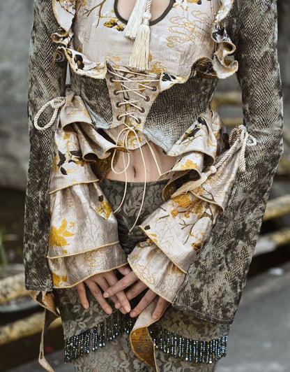 Staubgrüne Jacke mit kaskadierendem Rüschenbesatz und Schlangenleder-Narbung