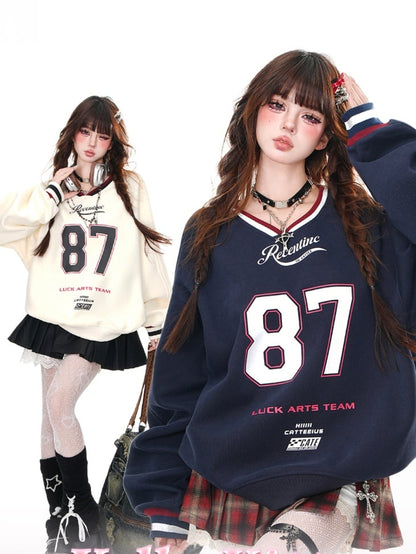 Aprikosen-/Marineblaues, lockeres Sweatshirt mit V-Ausschnitt und Zahlendruck in Bittersüß