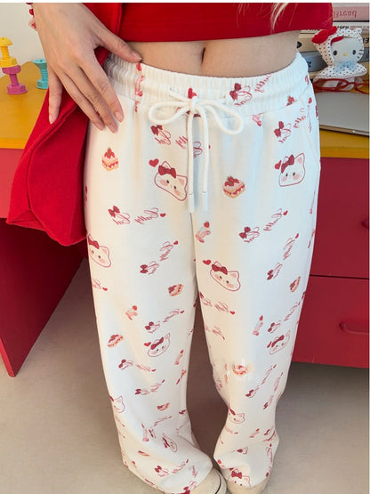 ホワイトのドローストリングウエスト、全体にキティプリントのワイドレッグカジュアルパンツ