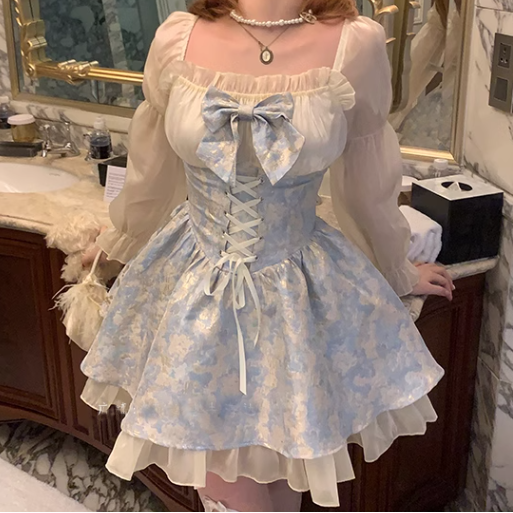 Person wearing a light blue and white floral dress with a bow in a bathroom setting.