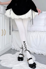 White tights with black crisscross ribbon at the ankle