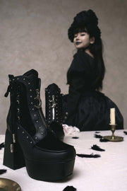 Black ankle boots with crescent zipper hardware in styling