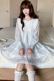 Seated view of blue dress and lace hem
