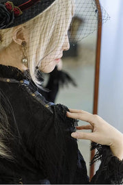 Rose brooch beside hat veil