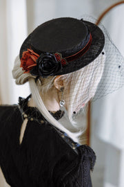 Rose brooch styled on a black hat