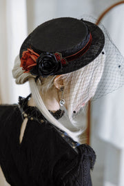 Red and black rose decoration on veiled hat