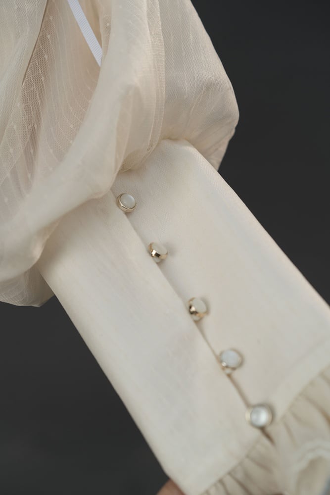 ベージュとブルーのフリルクロスオーバーネックライン長袖シャツ