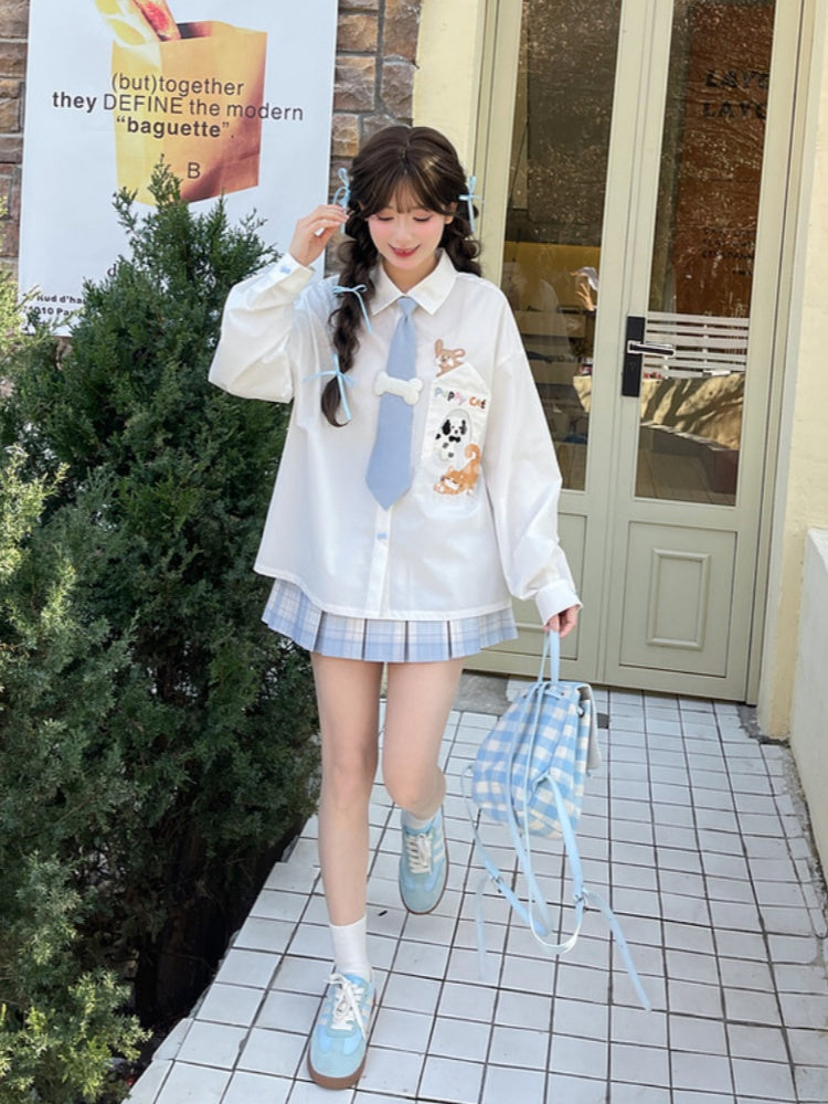 キティの青いネクタイとボーンパピーのアップリケがあしらわれた白いゆったりシャツ