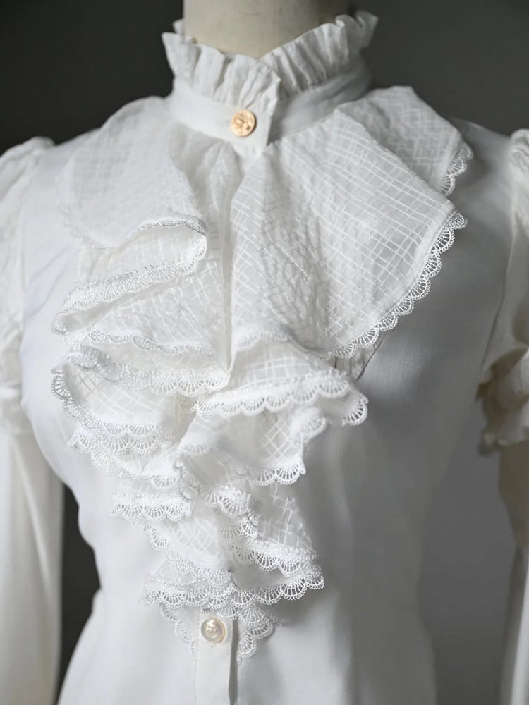 Chemise blanche asymétrique à manches longues, col jabot et ourlet à volants.