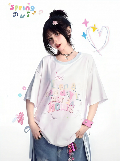 ゆったりとしたTシャツ。裾のディテール。ホワイトのラウンドネック。レタープリント。蝶結び。