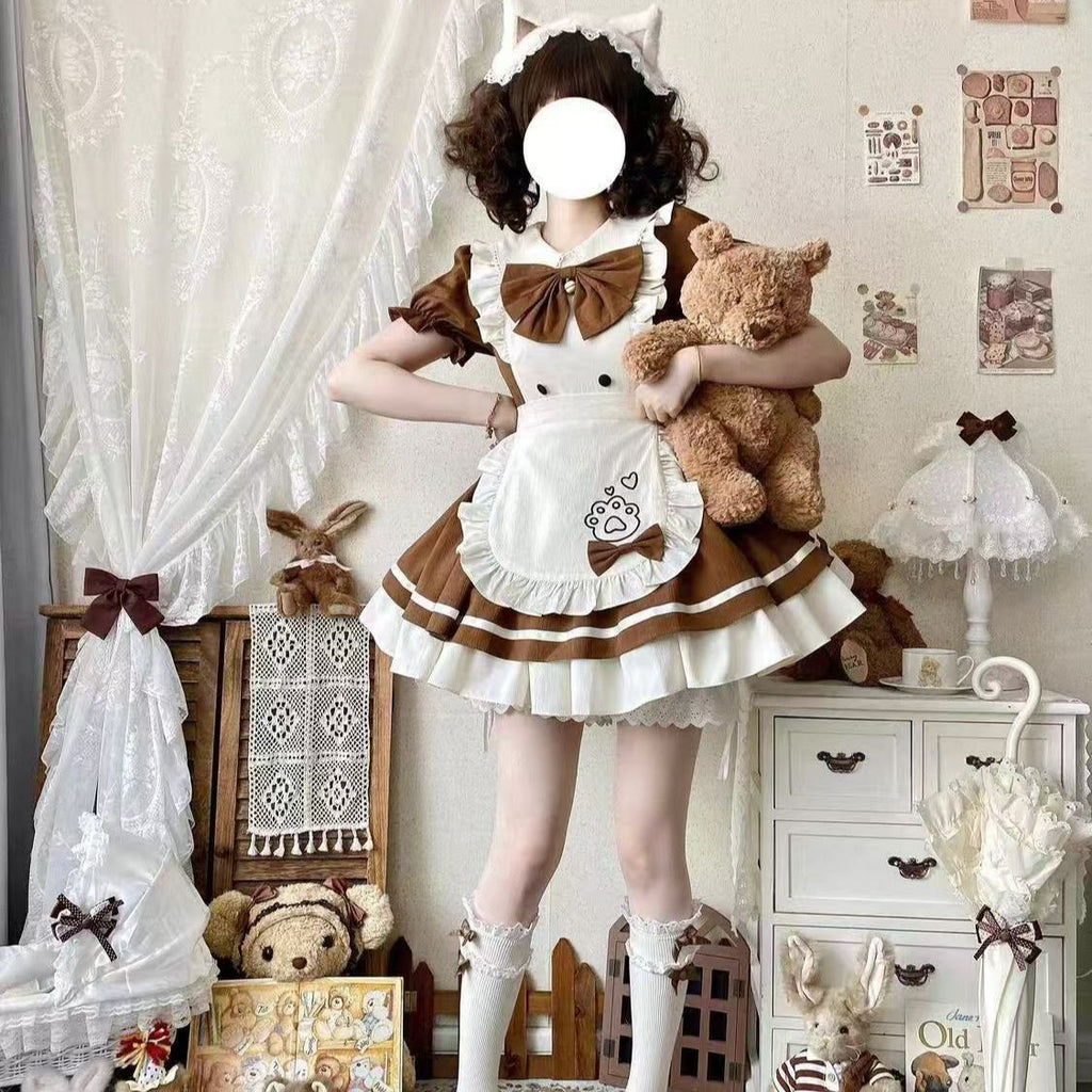 Person in a brown and white maid outfit holding teddy bears in a decorative room.