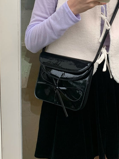 Elegant Black Crossbody Phone Pouch With Glossy Finish And Bow Accent