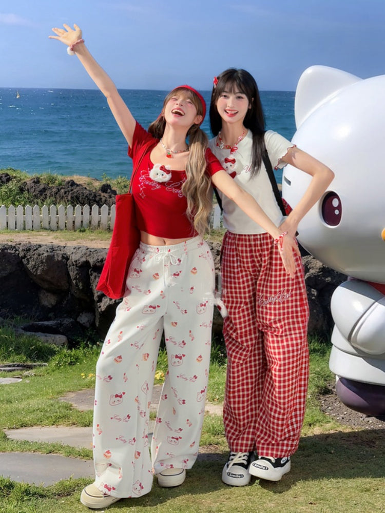 ホワイトのドローストリングウエスト、全体にキティプリントのワイドレッグカジュアルパンツ