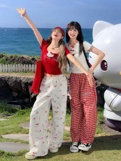 ホワイトのドローストリングウエスト、全体にキティプリントのワイドレッグカジュアルパンツ