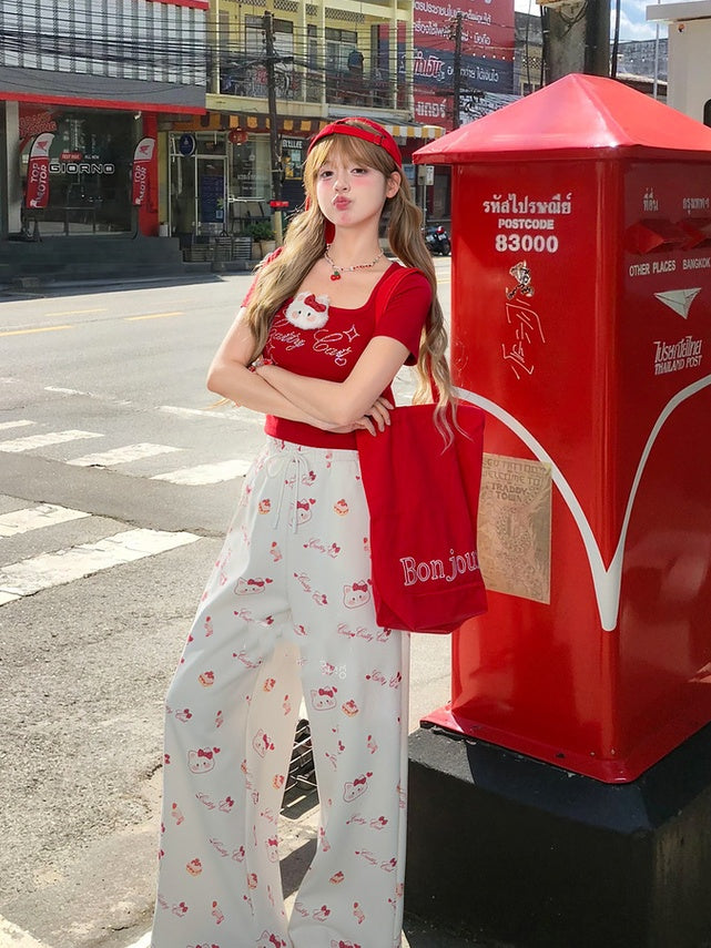 ホワイトのドローストリングウエスト、全体にキティプリントのワイドレッグカジュアルパンツ