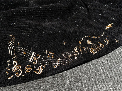 Schwarzes Ouji-Oberteil mit glitzernder Waffelstruktur, Musiknoten und Fransenschärpe