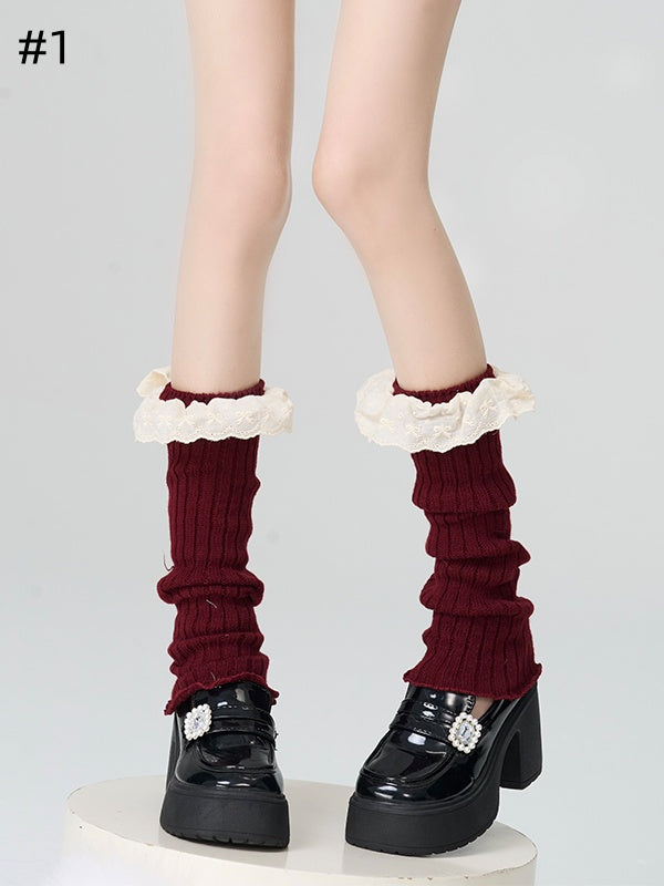 Gestrickte Beinwärmer mit rotem Spitzenbesatz