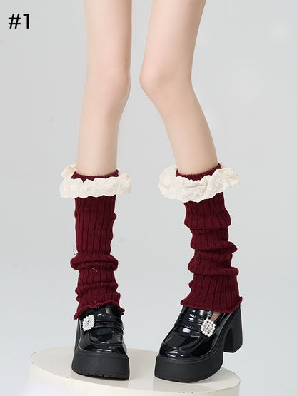 Gestrickte Beinwärmer mit rotem Spitzenbesatz