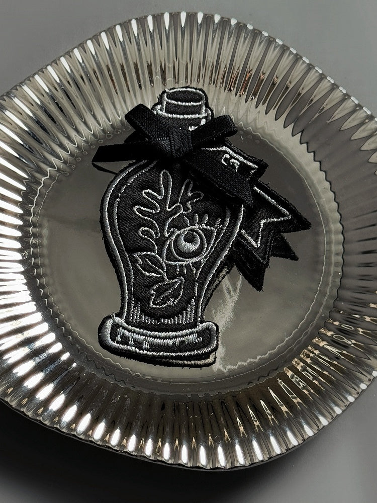 Schwarze Stickerei / Trankrote Brosche
