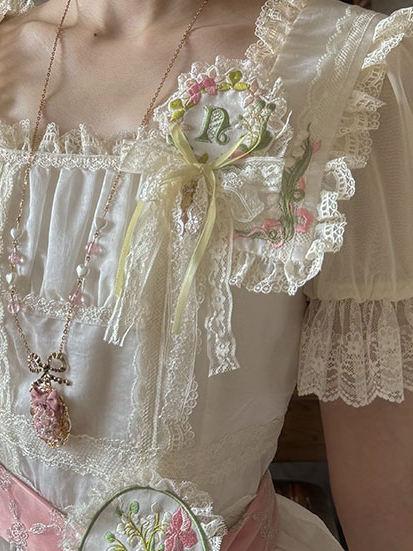 Blumenbrosche mit Spitzenbesatz und Stickerei