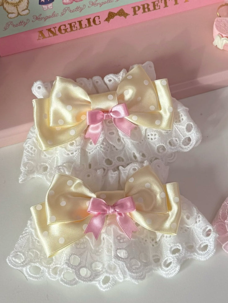 Gemusterte Handgelenkmanschetten mit rosa/gelbem Schleifendesign und Polka-Dot-Muster