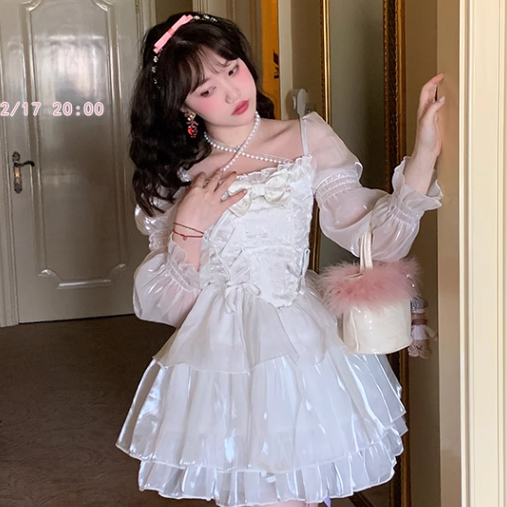 Woman in a white dress standing in front of a mirror.